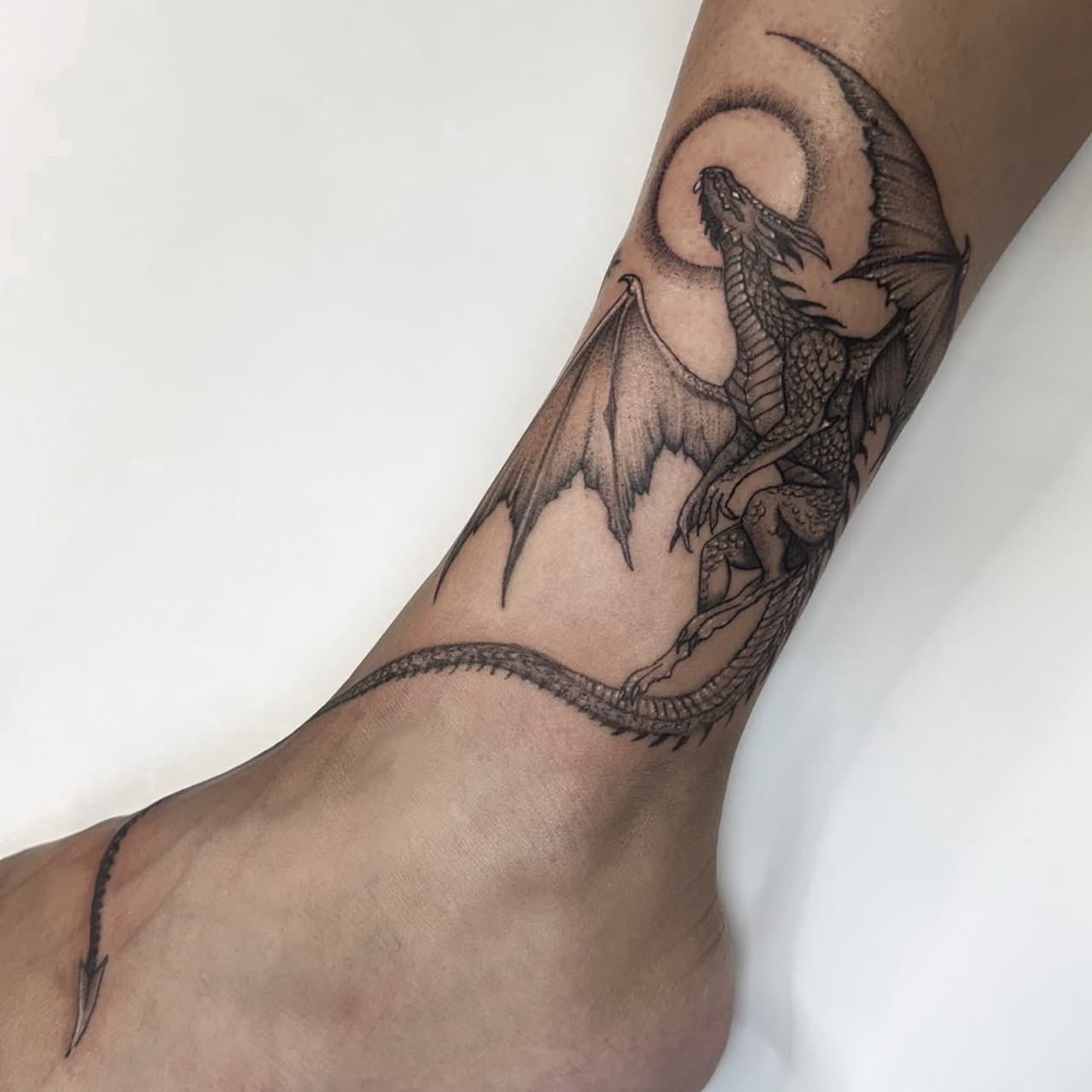 Black & Grey + Illustrative dragon tattoo on Ankle by Ashley_Jolly_Tattoo on TattMe
