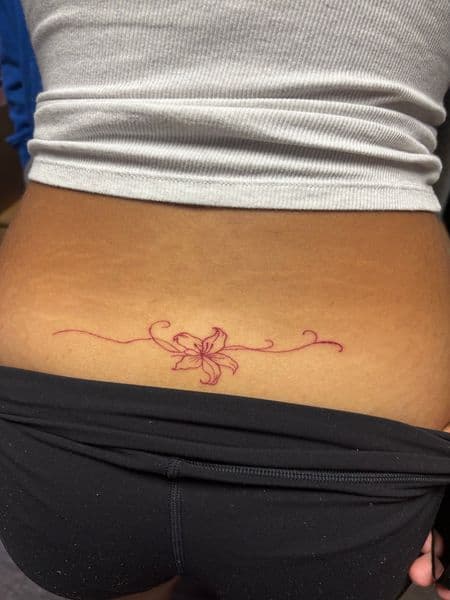 Fine Line + Minimalist lily tattoo on Lower Back by tatsbyrayyy on TattMe