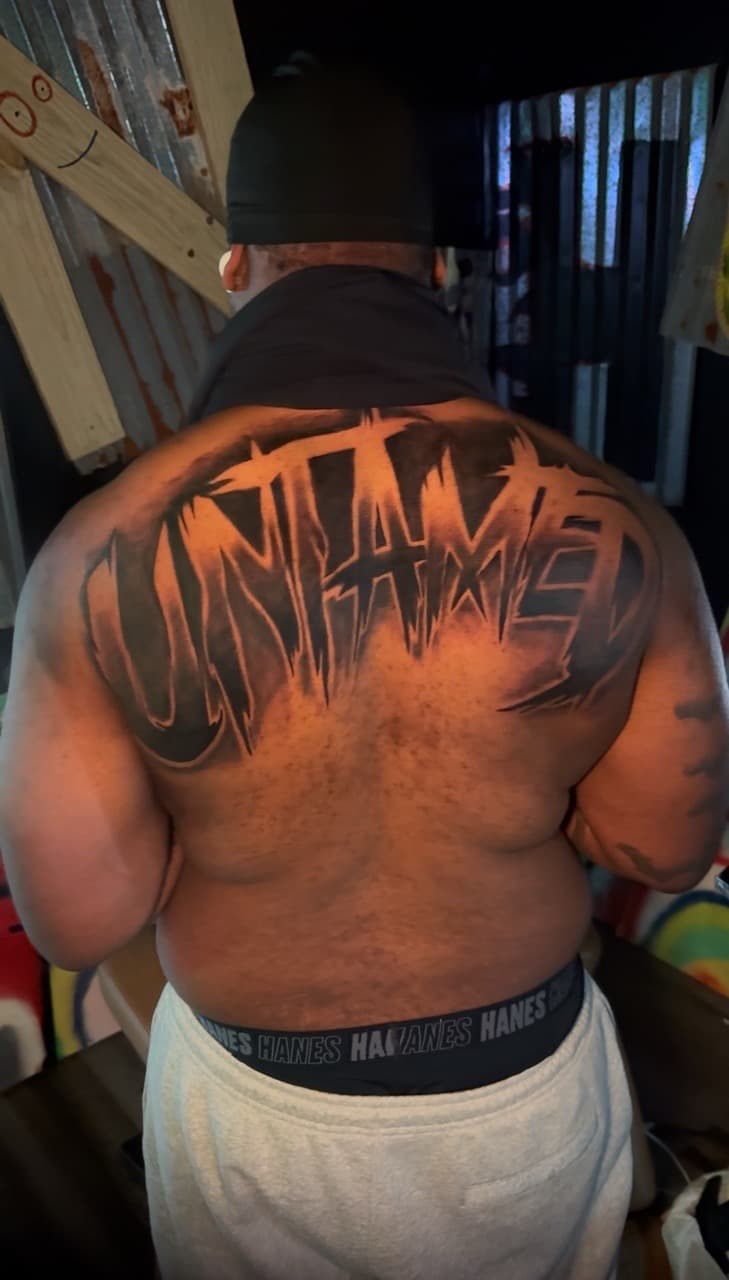 Lettering + Black & Grey untamed tattoo on Upper Back by Inkheadz on TattMe