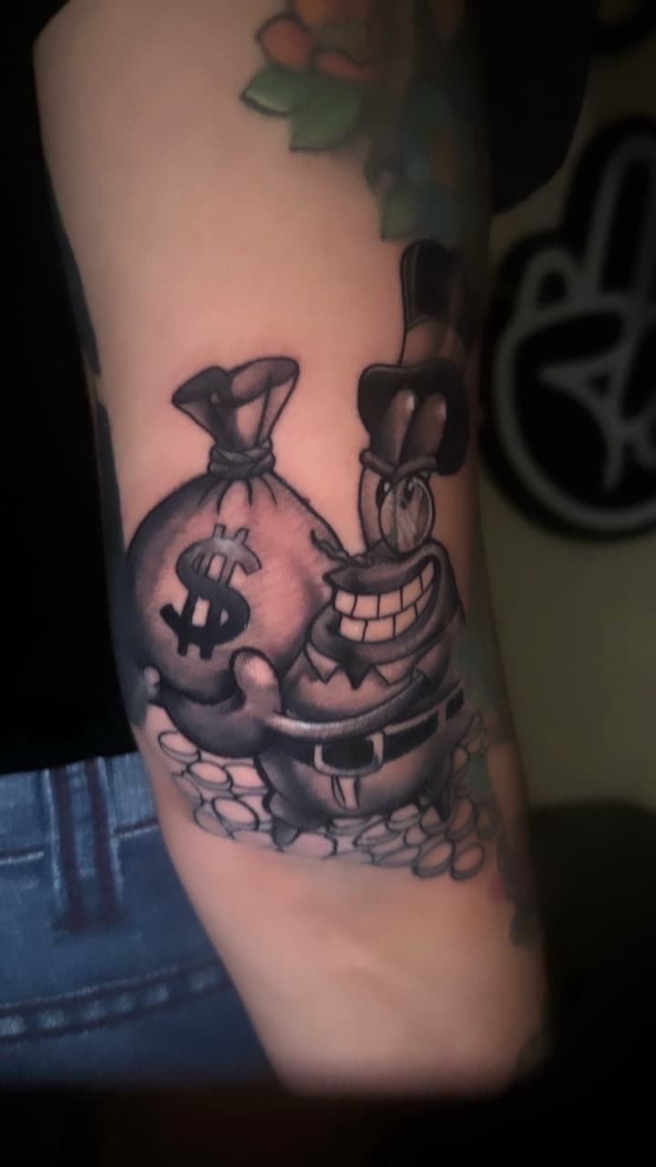 Black & Grey + Cartoon money bag tattoo on Upper Arm by LEGENDARY_HANDZ on TattMe