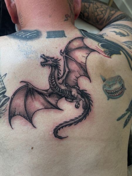 Black & Grey + Illustrative dragon tattoo on Upper Back by Skull_Brothers_Ink on TattMe