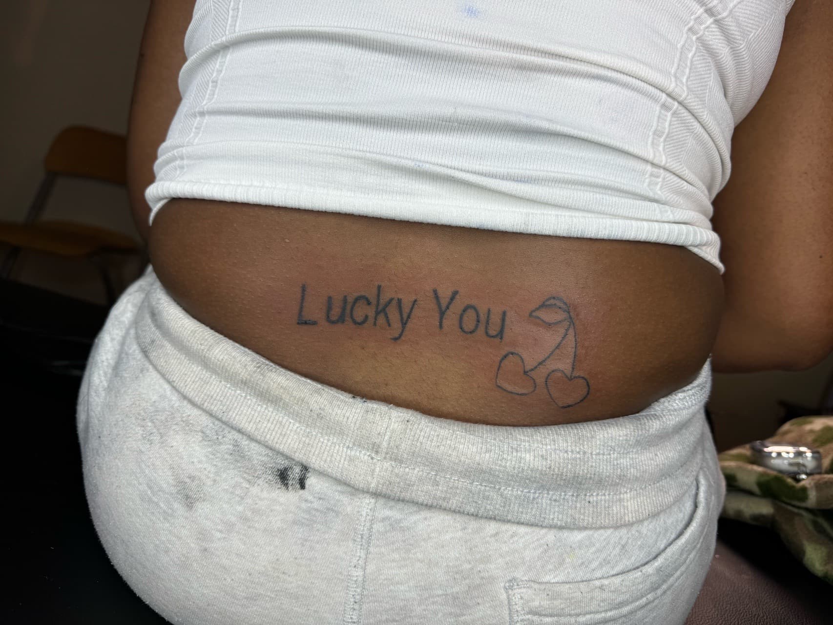 Lettering + Fine Line lips tattoo on Lower Back by InkByArtie on TattMe