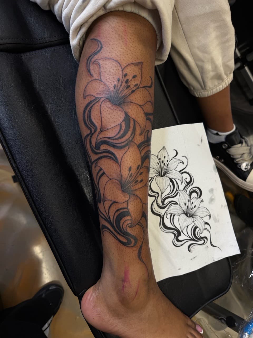 Floral + Black-work lilies tattoo on Shin by inkbyt0ny on TattMe