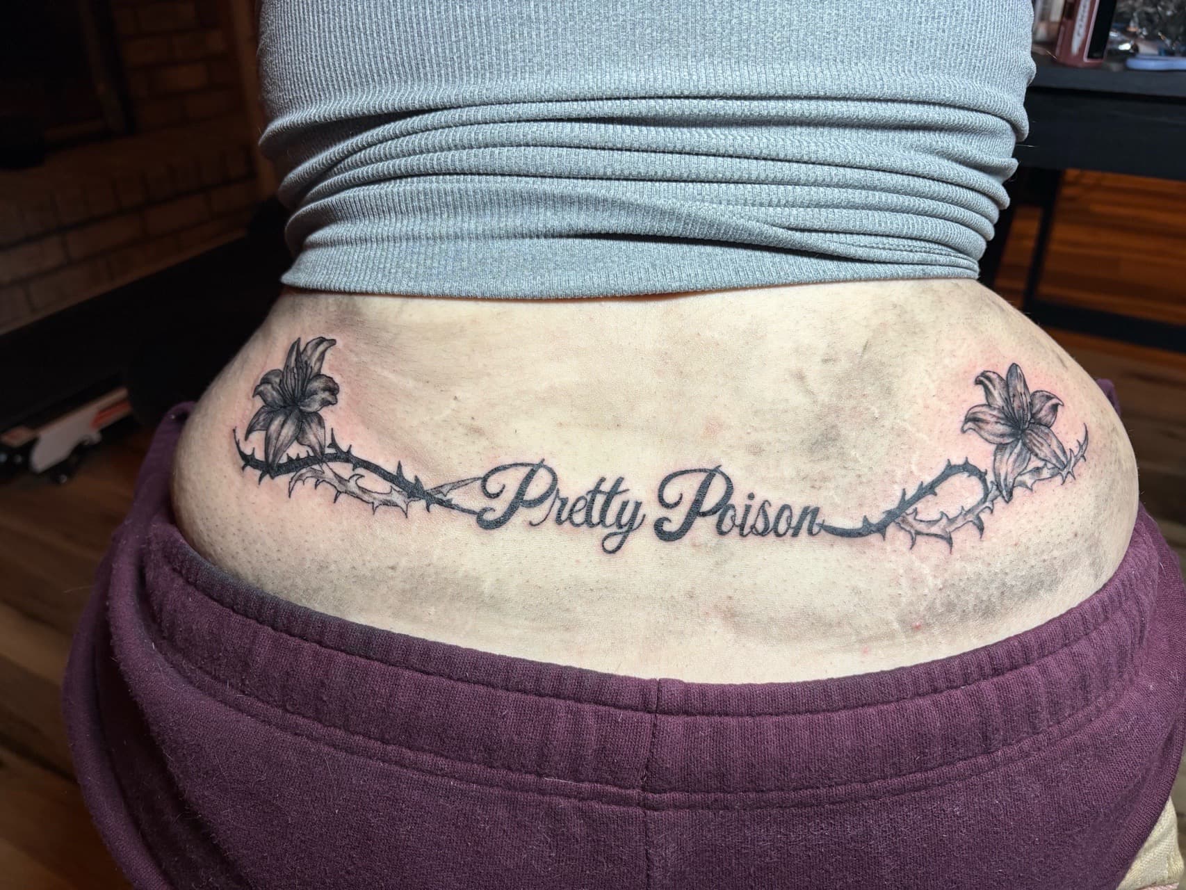 Black & Grey + Lettering lilies tattoo on Lower Back by TattedbyJayden on TattMe