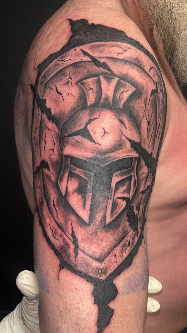 Black & Grey + Illustrative helmet tattoo on Upper Arm by Studio_22 on TattMe
