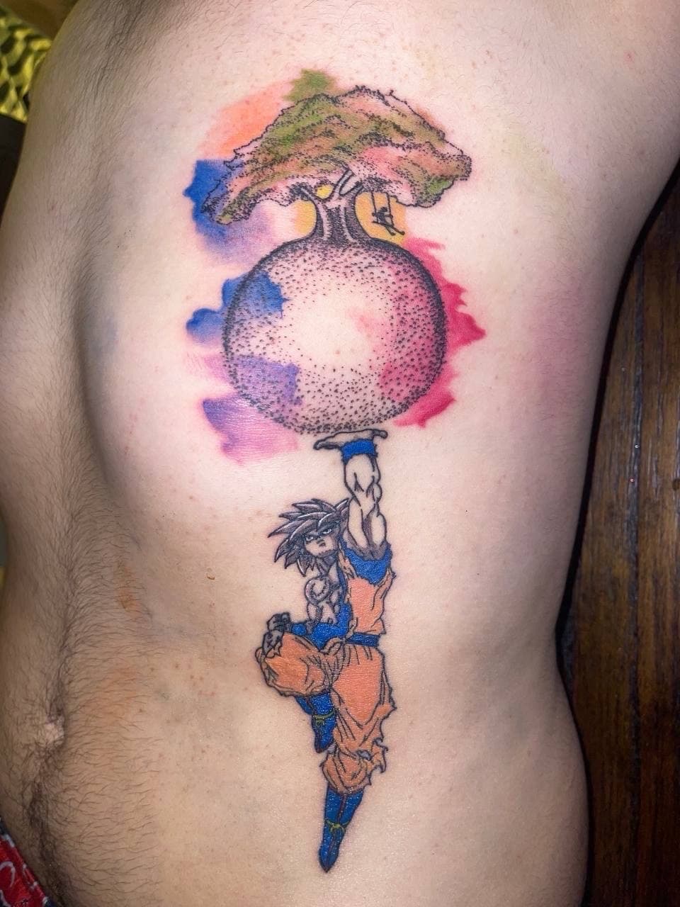 Anime + Watercolor goku tattoo on Ribs by ArtIsTatts on TattMe