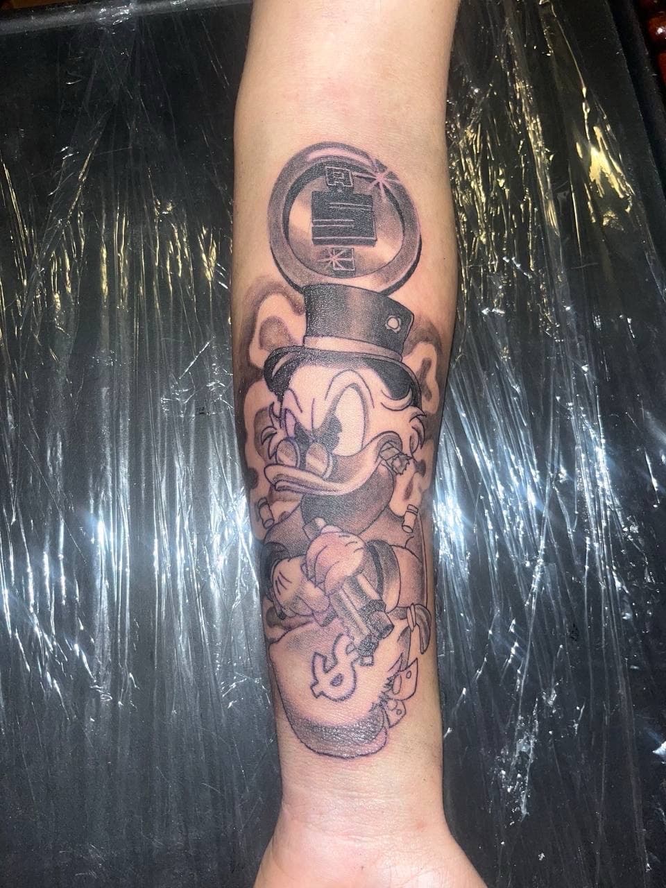 Black & Grey + Cartoon scrooge mcduck tattoo on Forearm by ArtIsTatts on TattMe