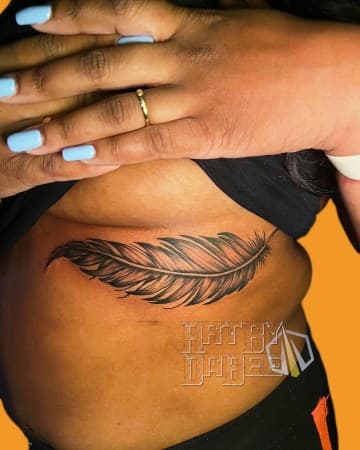 Black & Grey + Illustrative feather tattoo on Ribs by Artbydabee on TattMe