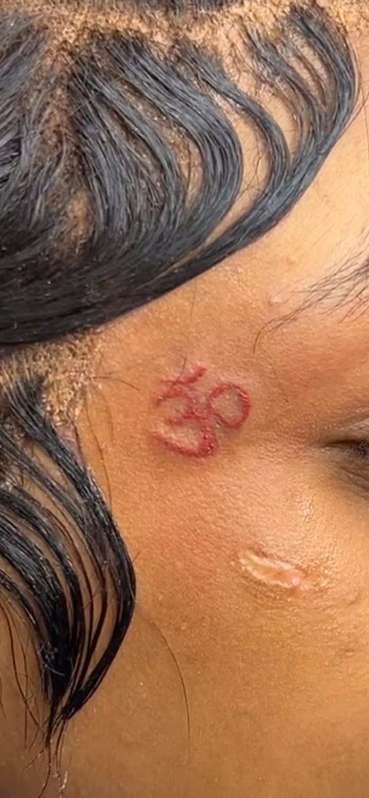 Fine Line + Color om symbol tattoo on Face by inkedbyk on TattMe