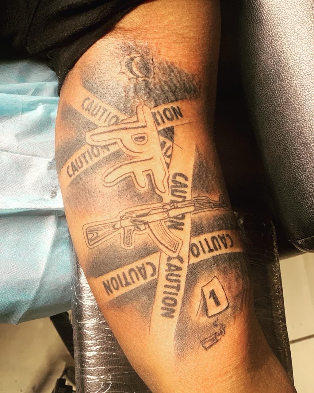 Black & Grey + Illustrative gun tattoo on Upper Arm by Mafia_Ink on TattMe