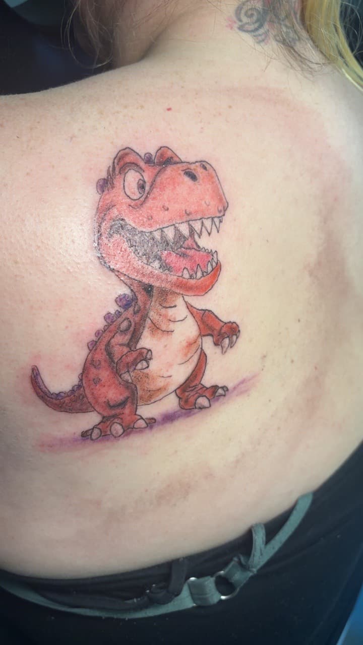 New School + Cartoon dinosaur tattoo on Shoulder Blade by Second_Chance_Tattoo_Studio on TattMe