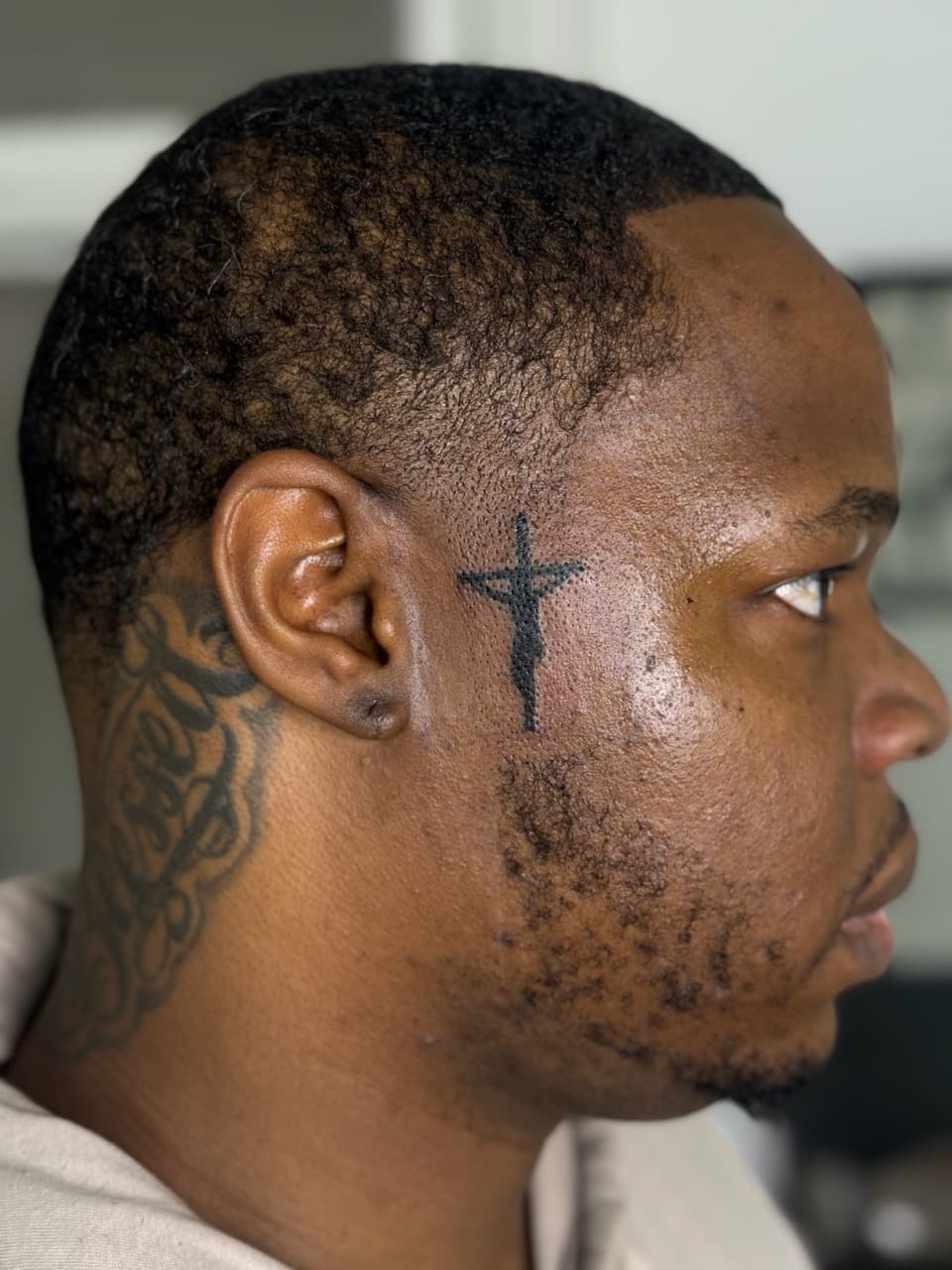Minimalist + Black-work cross tattoo on Face by KRUZ_TATTOOS on TattMe