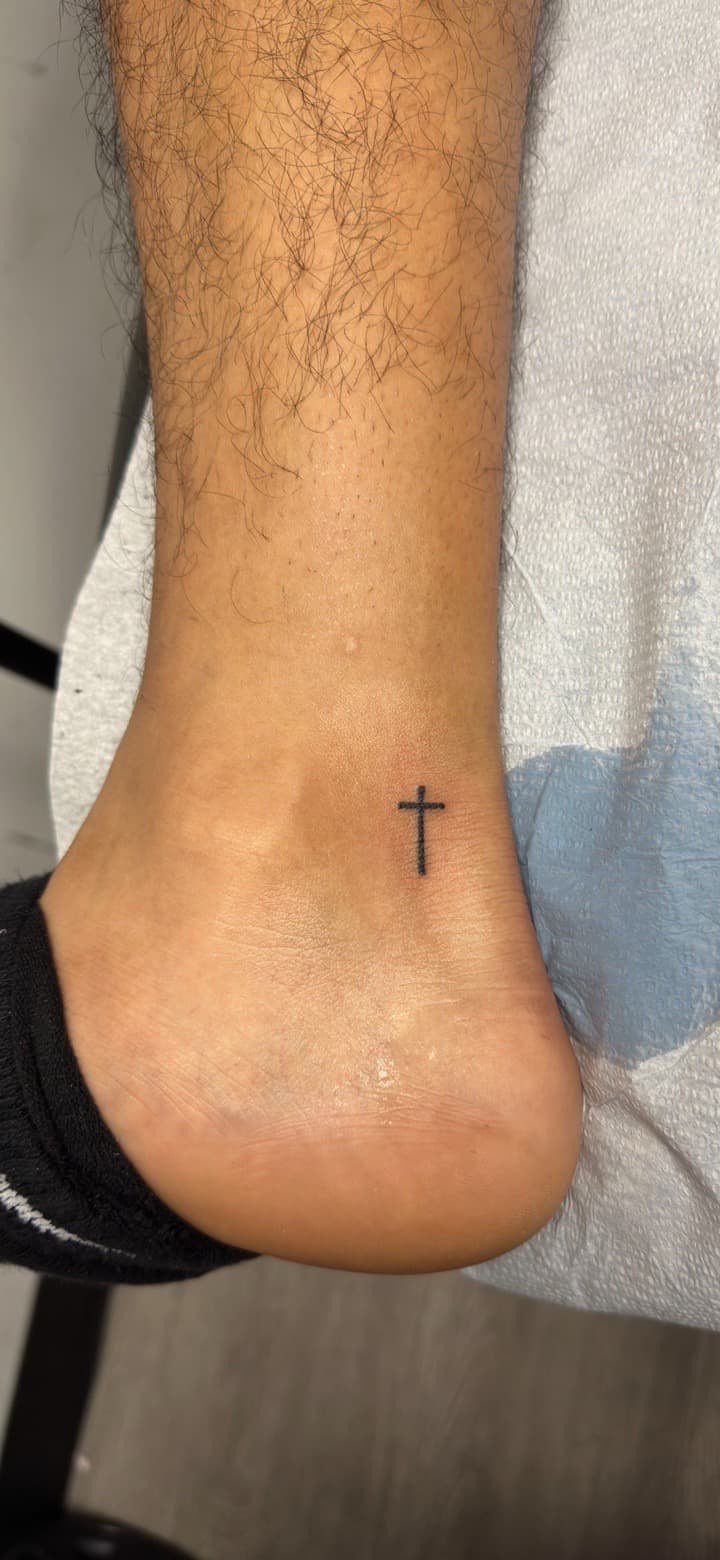 Minimalist + Fine Line cross tattoo on Ankle by Inkbyj on TattMe