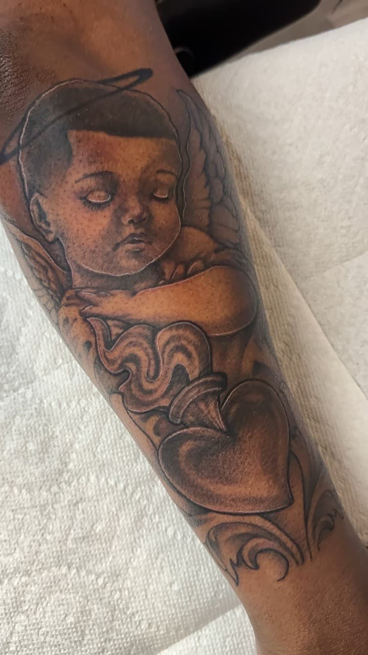 Black & Grey + Illustrative cherub tattoo on Forearm by Ink_by_Noble on TattMe
