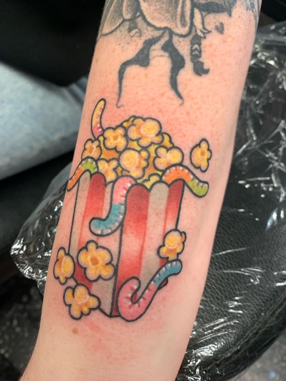 Color + Cartoon popcorn tattoo on Forearm by Mads_TwoTone_Roy on TattMe