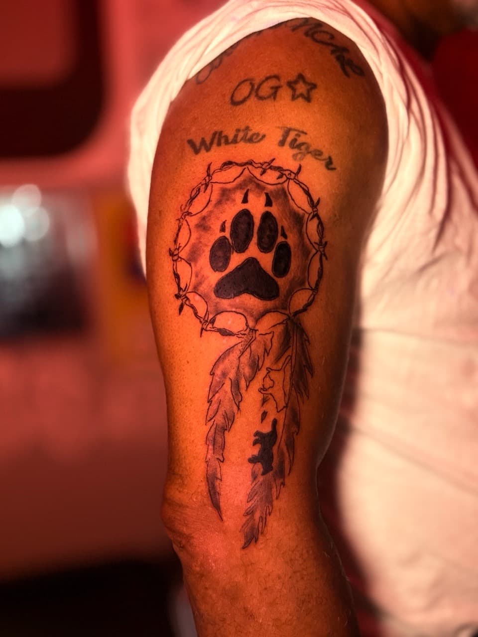 Black & Grey + Illustrative paw print tattoo on Upper Arm by Inkbyjmoney on TattMe