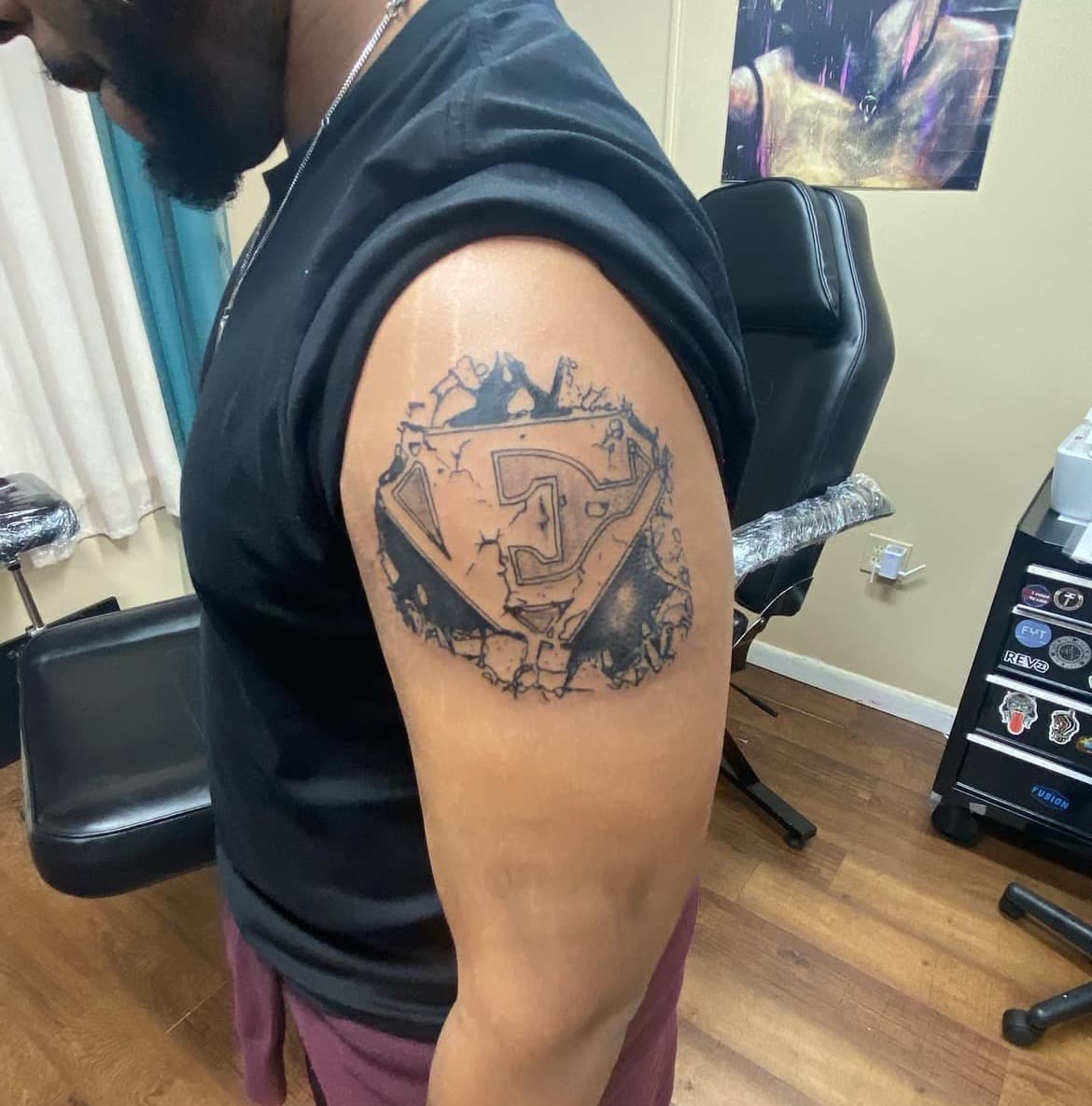Black & Grey + Illustrative logo tattoo on Upper Arm by Titan_Ink on TattMe