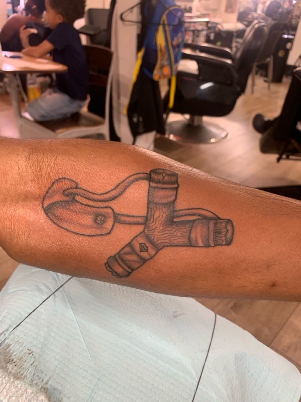Black & Grey + Illustrative slingshot tattoo on Forearm by Modest_Ink_Ellz on TattMe