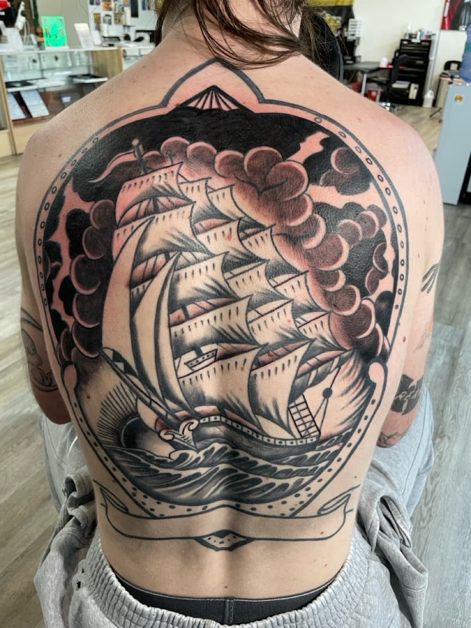 Black & Grey + American Traditional ship tattoo on Upper Back by all_saints_social on TattMe