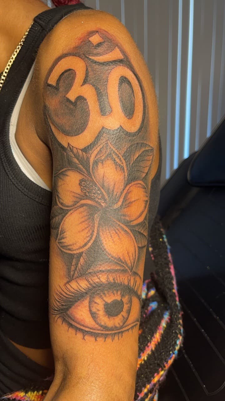 Black & Grey + Floral om symbol tattoo on Upper Arm by MauryTatz on TattMe