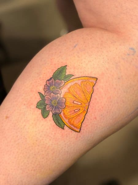 Color + Illustrative orange slice tattoo on Upper Arm by Kiwi on TattMe