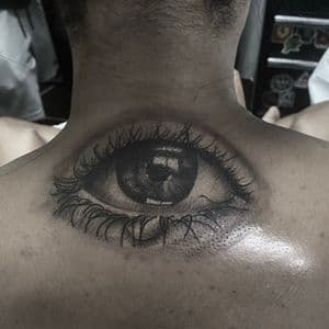 Black & Grey + Portrait Realism eye tattoo on Upper Back by Tattoos_By_Danny_Cruz on TattMe
