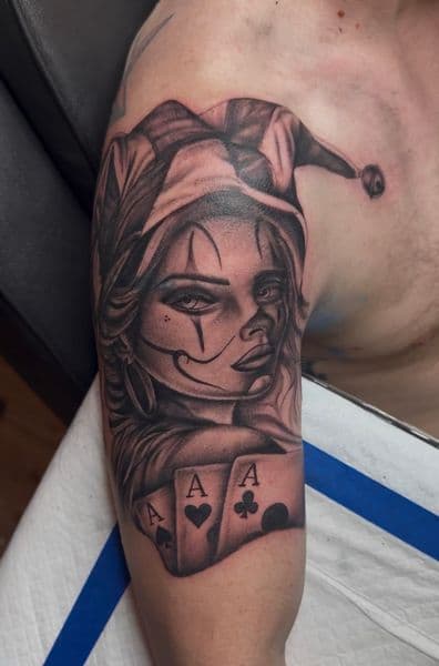 Black & Grey + Realism jester tattoo on Upper Arm by InkedbyJunior on TattMe