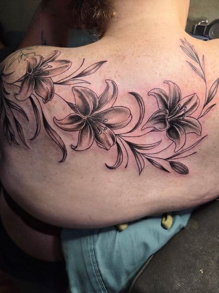 Black & Grey + Floral lilies tattoo on Upper Back by Certified__OB on TattMe