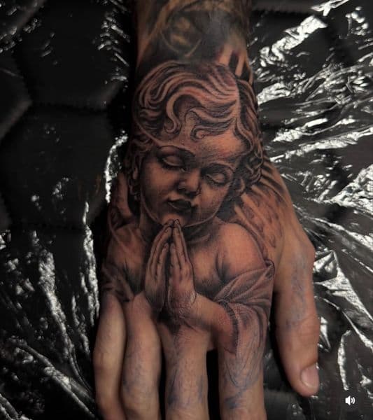 Black & Grey + Realism cherub tattoo on Hand by Sydd_Tattoo_studio_ on TattMe