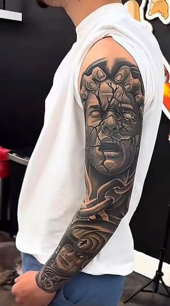 Black & Grey + Realism cracked face tattoo on Full Sleeve by Insane_Ink_Studio_ on TattMe