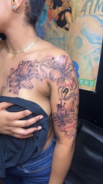 Floral + Lettering lilies tattoo on Shoulder by the_goat_images_ on TattMe