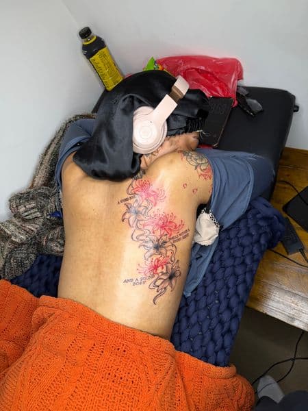 Floral + Line-work spider lilies tattoo on Upper Back by itattyedyabihh on TattMe